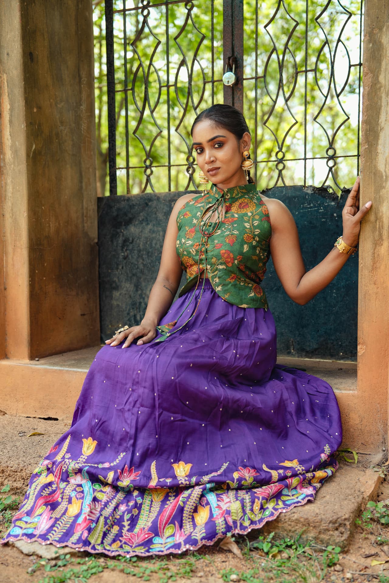 Seated view of the purple embroidered skirt set, showing the fall of the skirt.